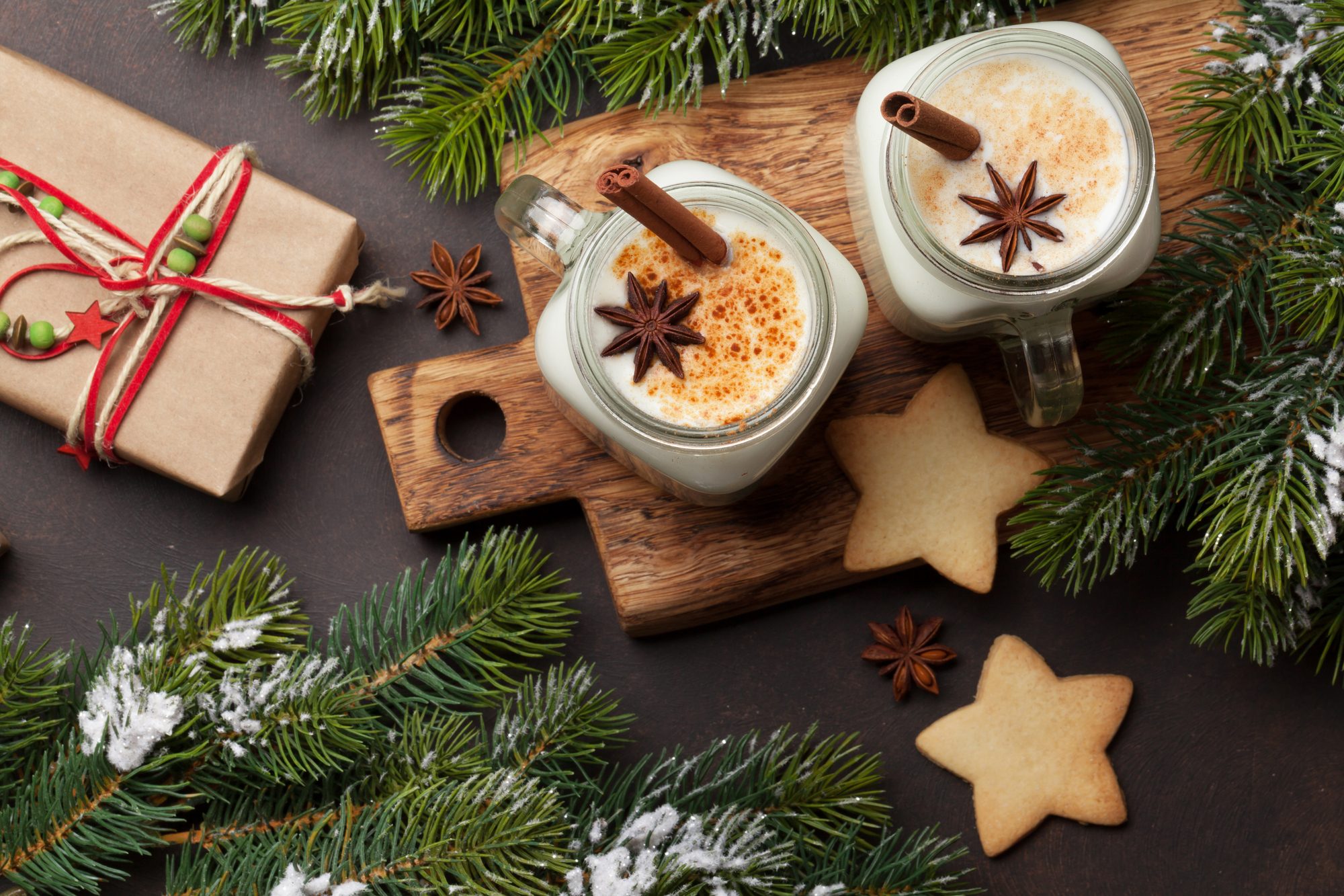 Eggnog. Traditional christmas cocktail and gingerbread cookies with xmas gift box and firtree. Flat lay. Top view